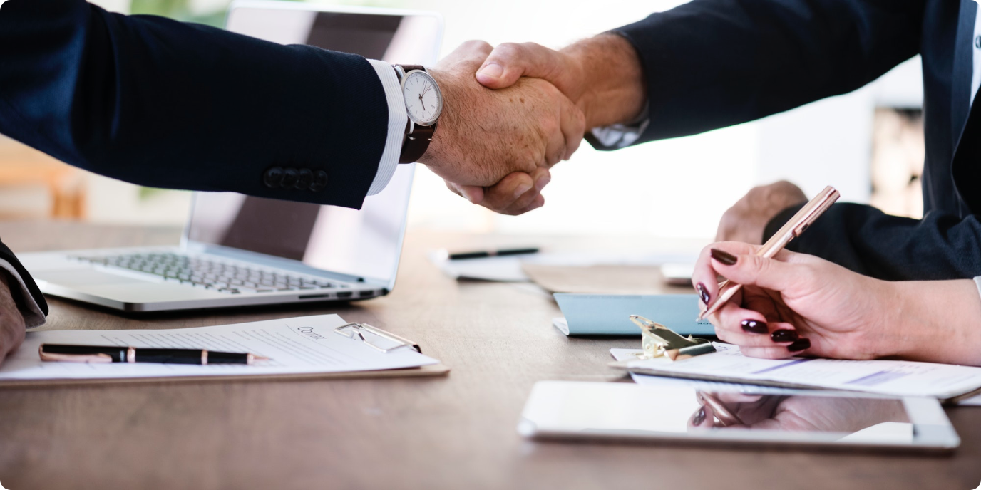 Two meeting participants shaking hands over the table.